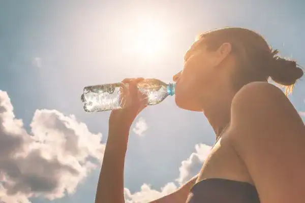 Hydration: The Secret Ingredient for a Toned Stomach and Enhanced Fitness 3 Image of woman drinking water to hydrate Southall after run.