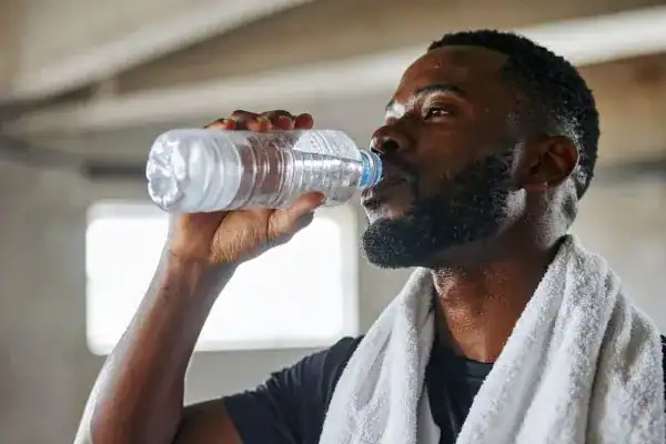 Hydration: The Secret Ingredient for a Toned Stomach and Enhanced Fitness 1 Image of man drinking water to improve hydration Southall after work out.